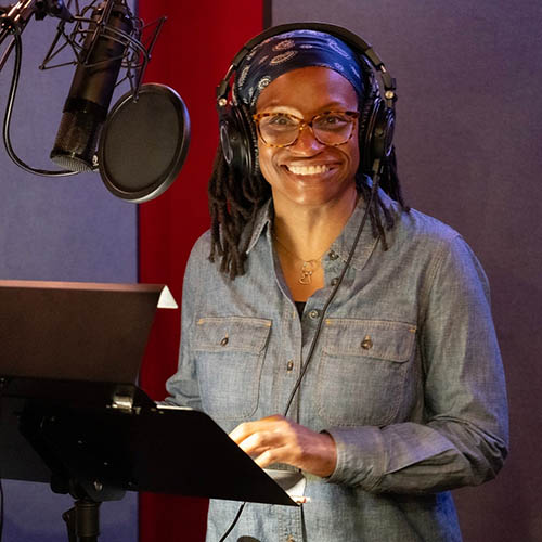 Smiling woman in a voice over booth